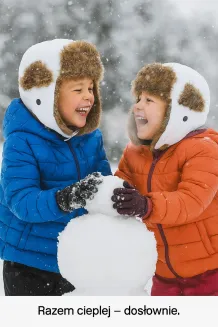 Fotografia lifestyle pokazująca dziecko podczas zabawy na śniegu w czapce W151G ekry marki Polar Fashion. Widoczne miękkie futerko i wysoki daszek chroniący twarz. Idealne zdjęcie promocyjne oddające funkcję ochronną i emocjonalny aspekt produktu – radość, bezpieczeństwo i komfort cieplny w zimowych warunkach.